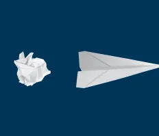 Crumpled paper ball next to paper airplane