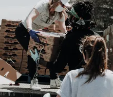 Volunteer handing a box to another volunteer