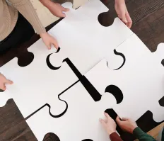 People holding puzzle pieces together