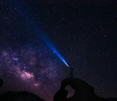 Person holding a flashlight on a mountain
