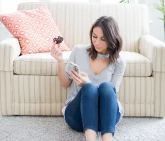 A lady sitting next to a sofa