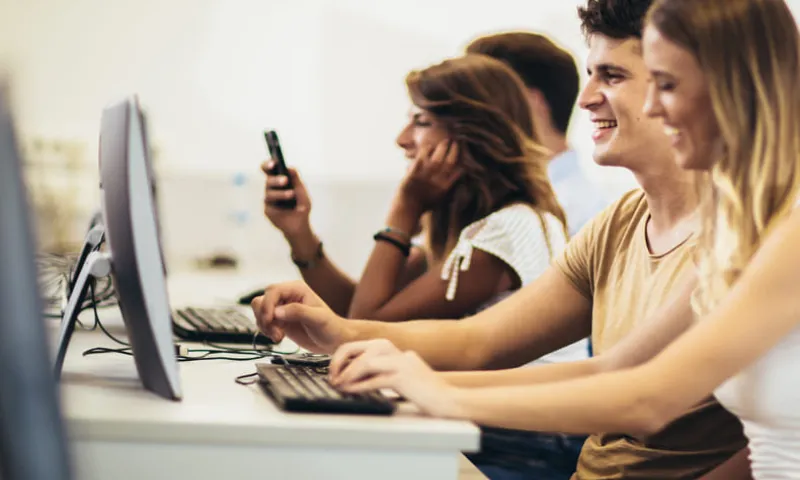 Students working on computers together in a university computer lab.