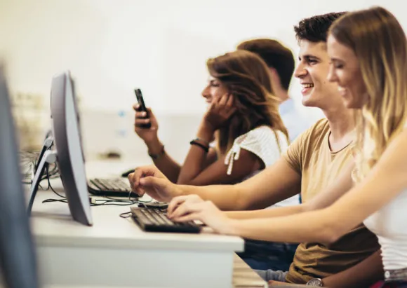 Students working on computers together in a university computer lab.