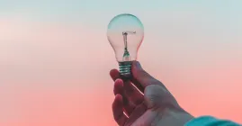 lightbulb held up to a sunset