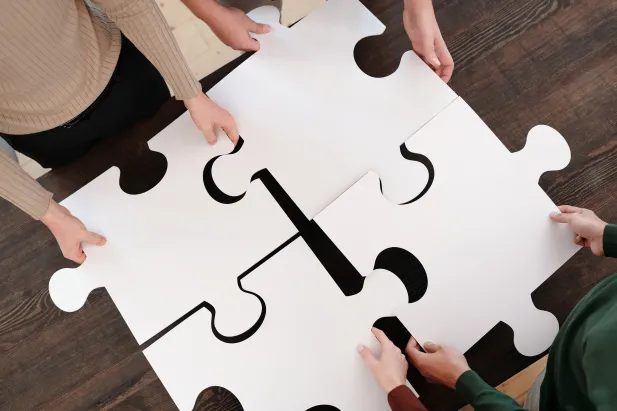 People holding puzzle pieces together