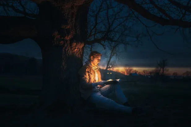 Person reading glowing book