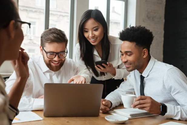Coworkers surrounding laptop