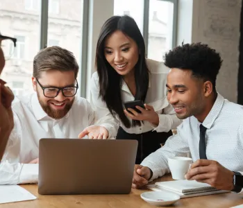 Coworkers surrounding laptop