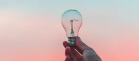 lightbulb held up to a sunset