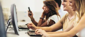Students working on computers together in a university computer lab.