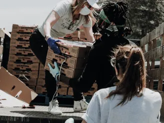 Volunteer handing a box to another volunteer