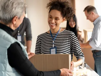 Volunteer handing a box to another volunteer