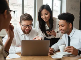 Coworkers surrounding laptop