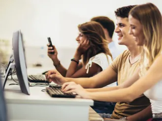 Students working on computers together in a university computer lab.