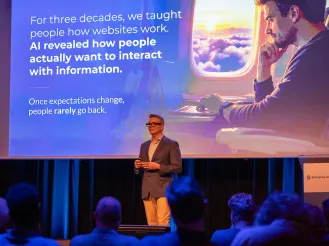 Gleen presenting on stage to a seated audience, with a slide explaining how AI is changing the way people interact with information.