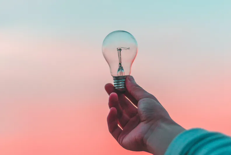 lightbulb held up to a sunset