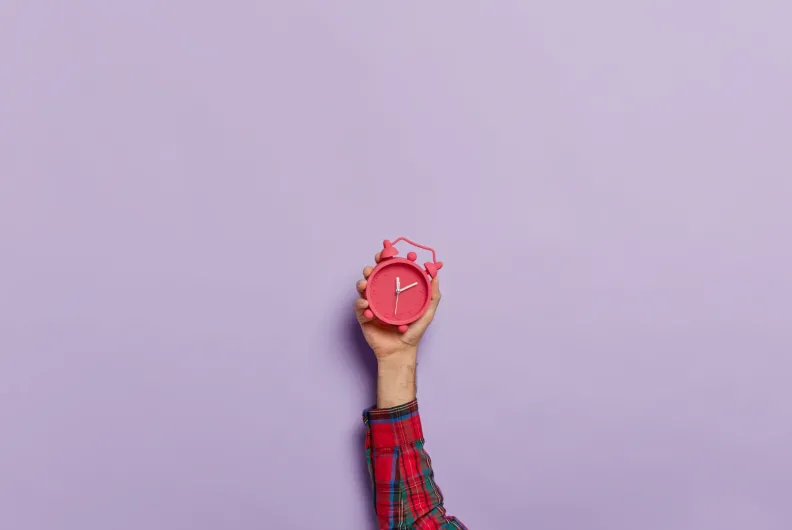 hand holding up a clock