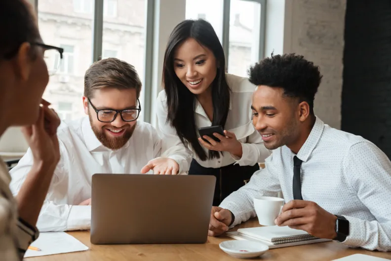 Coworkers surrounding laptop