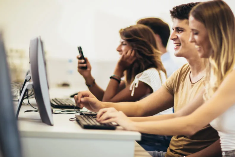 Students working on computers together in a university computer lab.